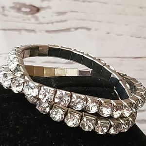Two silvertone metal stretch bracelets with clear rhinestones